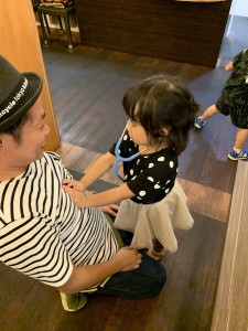 祖母の古稀のお祝いの時に、次女がおもちゃの聴診器でみんなを元気にするとみてまわっている時の写真です。