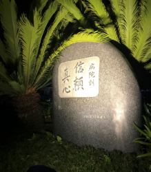 創業時から中央眼科の象徴として、玄関に植えられていた「ソテツ」と病院訓(創業者訓)としてグループの基本理念を刻んだ「石像」がライトアップされた幻想的な写真です。
今後永遠に引き継がれていく基本理念の「信頼」「真心」はタイトル通り創業者からの「伝承」そのものです。(ソテツは旧病院の玄関に有ったソテツ移植した物です。)
中央眼科の解体作業から新築工事の建て替えを担当し解体される建物を懐かしみ、寂しく想い涙した事や、新築が進む中、新しい風を起こすわくわく感を体験させて頂きました。
それは創業者のお二人が、創りあげて来て下さったからこその経験と体験です。改めて土屋名誉会長、土屋多恵子専務に「ありがとうございます」とお伝えしたくこの写真を選びました。